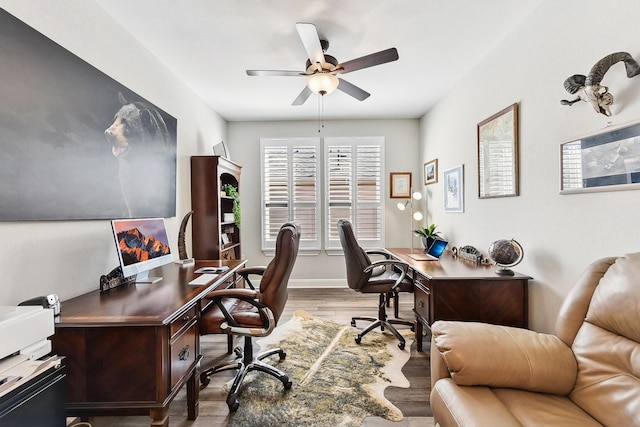 office with light hardwood / wood-style flooring and ceiling fan