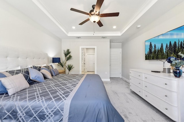 carpeted bedroom featuring crown molding, ceiling fan, a tray ceiling, and ensuite bath