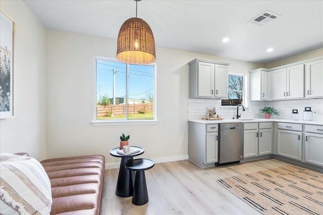 kitchen with pendant lighting, sink, gray cabinetry, tasteful backsplash, and stainless steel dishwasher