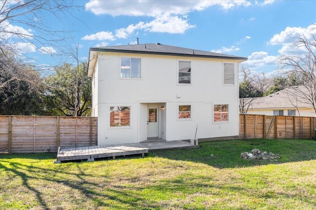 back of property featuring a yard and a deck