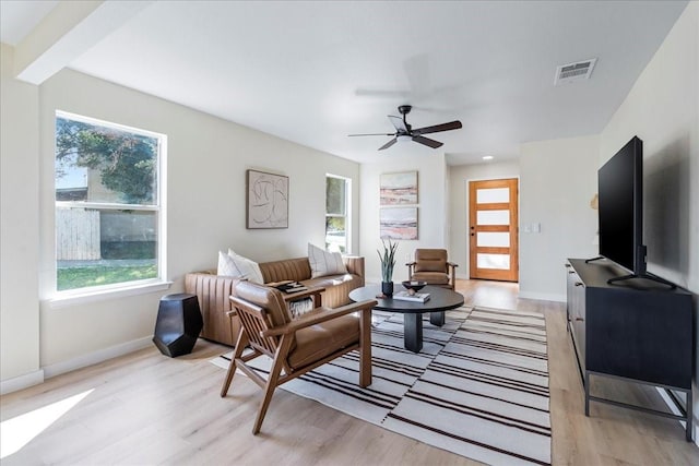 living room featuring ceiling fan, light hardwood / wood-style flooring, and a healthy amount of sunlight