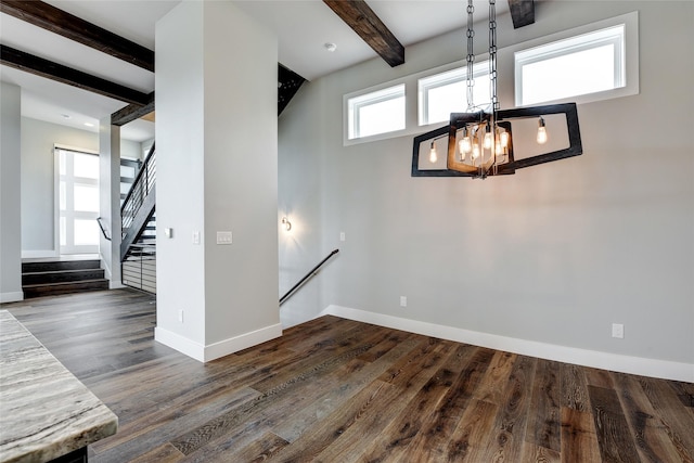 interior space featuring dark hardwood / wood-style floors, beam ceiling, and a notable chandelier