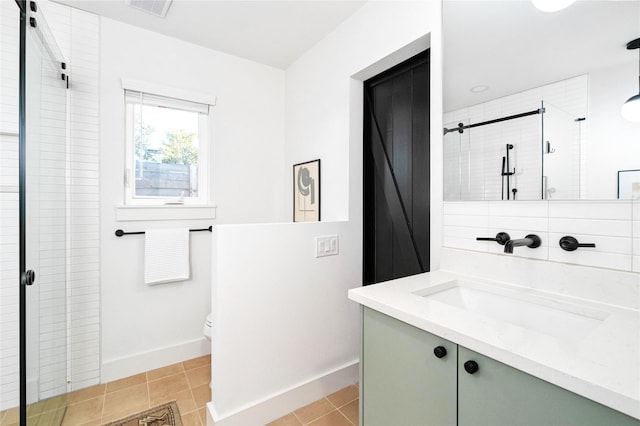 bathroom with tile patterned flooring, vanity, a shower with shower door, and toilet