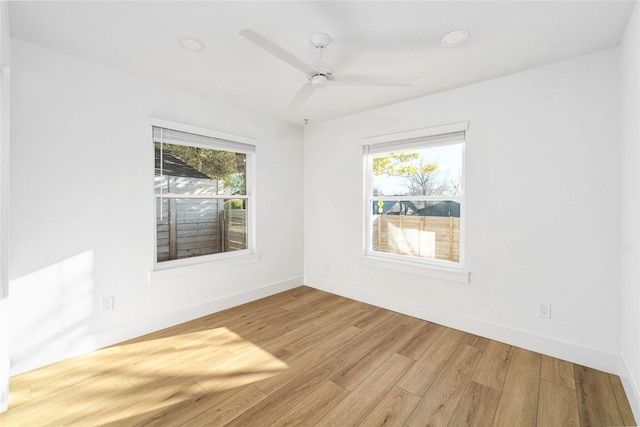 empty room with light hardwood / wood-style flooring, a wealth of natural light, and ceiling fan