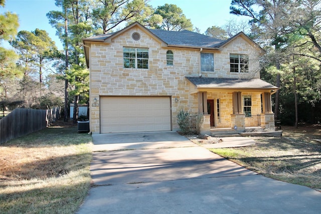 view of front of house featuring cooling unit, a garage, and a porch