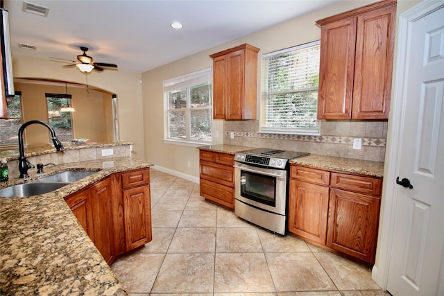 kitchen featuring sink, stainless steel range with electric cooktop, decorative backsplash, light tile patterned floors, and ceiling fan