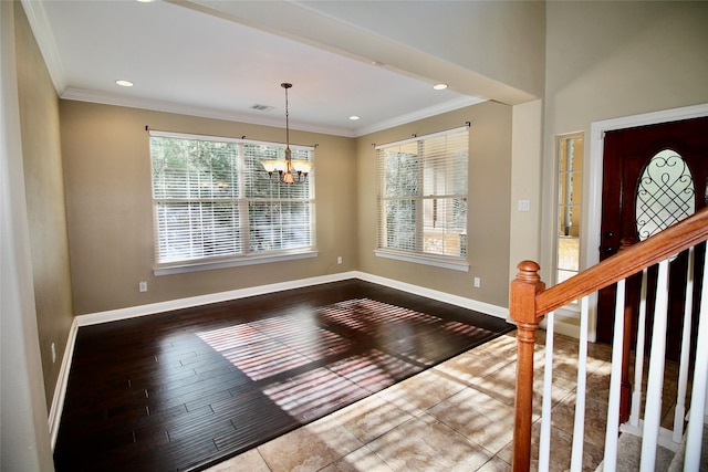 foyer entrance featuring ornamental molding, a chandelier, and hardwood / wood-style floors