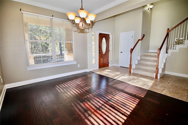 foyer featuring hardwood / wood-style flooring, ornamental molding, and a chandelier