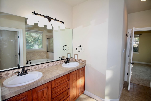 bathroom with a washtub, vanity, and tile patterned floors