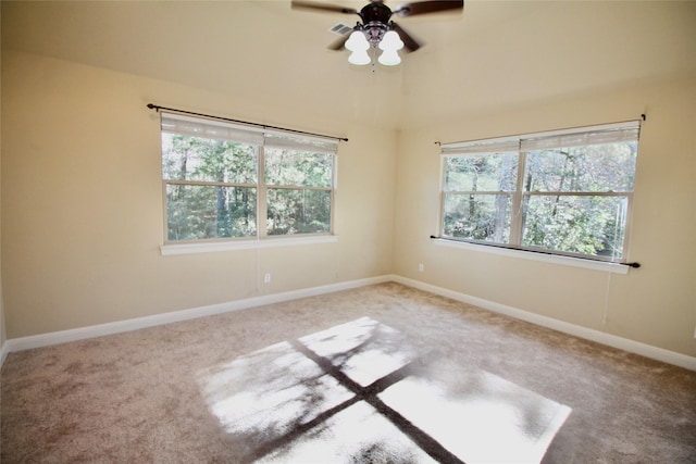 empty room with ceiling fan, carpet floors, and a wealth of natural light