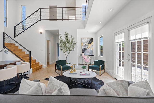 living room featuring a towering ceiling, french doors, and light tile patterned flooring