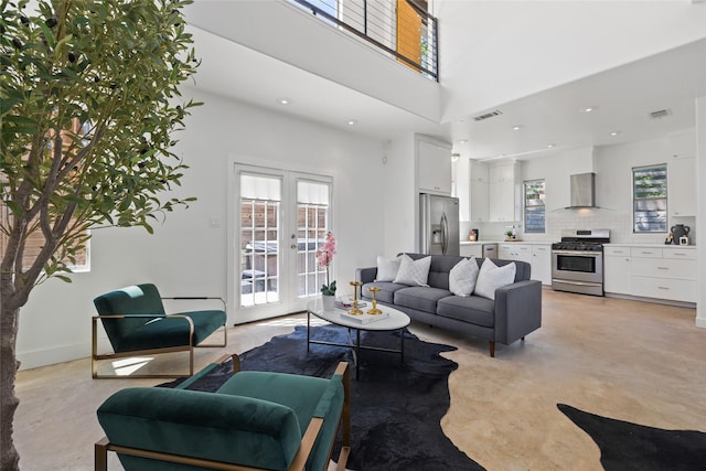 living room with a towering ceiling and french doors