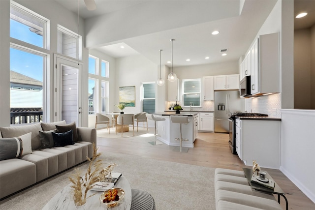 living room featuring light hardwood / wood-style flooring and a high ceiling