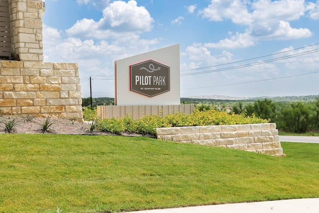 community / neighborhood sign featuring a lawn