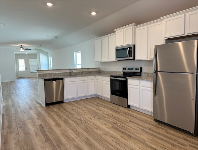 kitchen with white cabinetry, light wood-type flooring, stainless steel appliances, and lofted ceiling