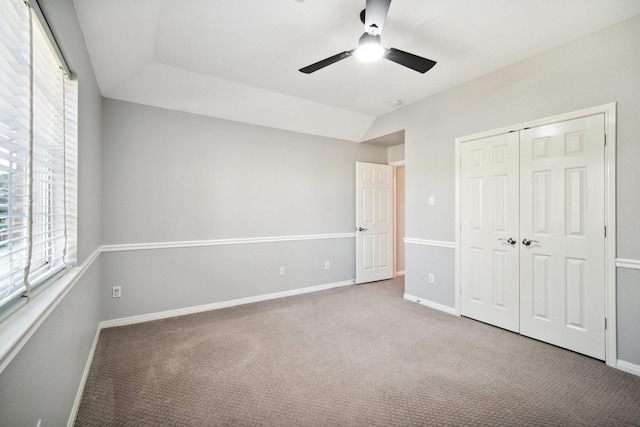 unfurnished bedroom with carpet floors, vaulted ceiling, a closet, and ceiling fan