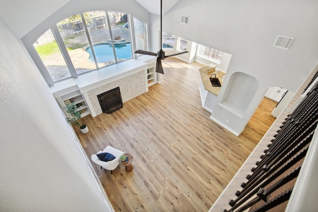 unfurnished living room with lofted ceiling, sink, and light hardwood / wood-style floors