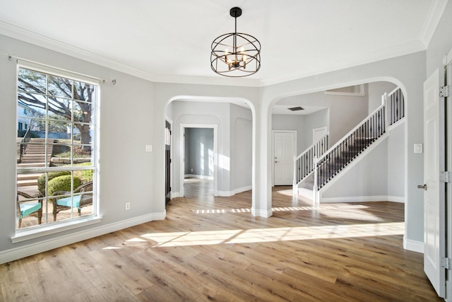 unfurnished dining area featuring crown molding, a notable chandelier, and light hardwood / wood-style floors