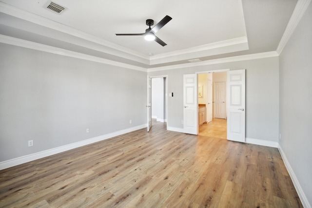 unfurnished bedroom with ceiling fan, ornamental molding, a tray ceiling, and light hardwood / wood-style flooring