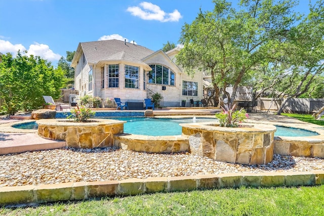 view of swimming pool with a hot tub