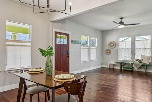 dining space featuring dark hardwood / wood-style flooring, ceiling fan with notable chandelier, and a healthy amount of sunlight