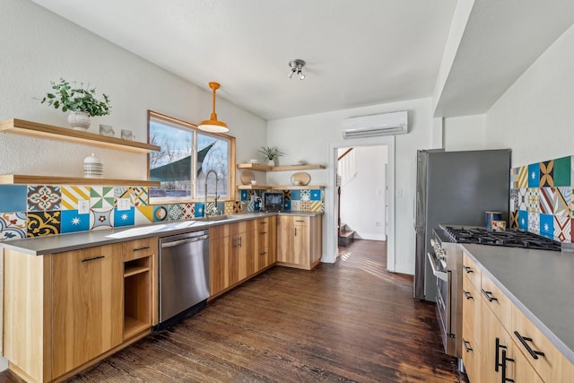 kitchen featuring appliances with stainless steel finishes, an AC wall unit, pendant lighting, light brown cabinetry, and sink