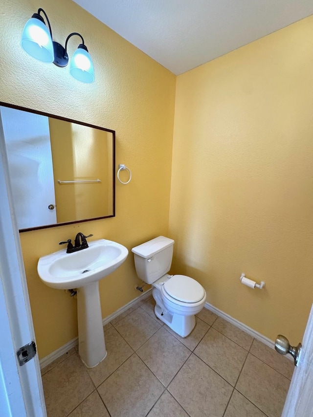 bathroom with toilet and tile patterned flooring