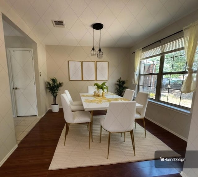 dining area with baseboards, visible vents, and wood finished floors