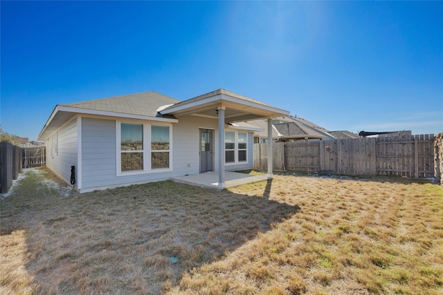 rear view of property with a yard and a patio area