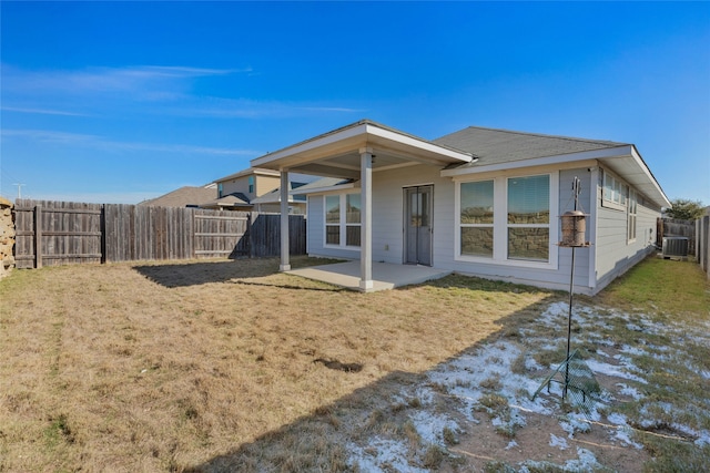 back of property featuring a lawn, central air condition unit, and a patio area