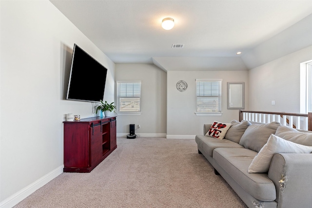 living room with lofted ceiling, plenty of natural light, and light colored carpet