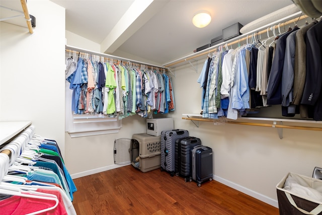 spacious closet featuring dark wood-type flooring and vaulted ceiling with beams