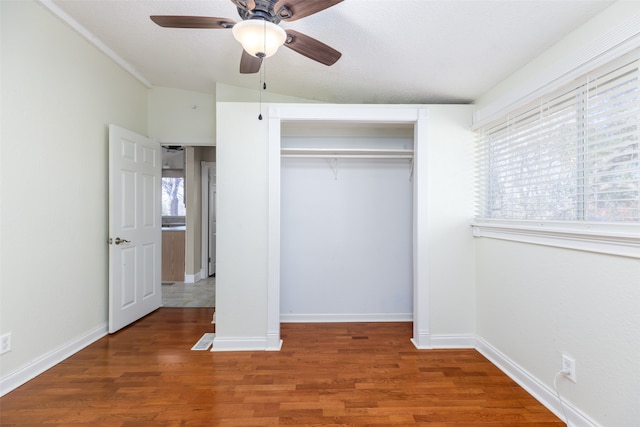 unfurnished bedroom featuring ceiling fan, dark hardwood / wood-style floors, and a closet