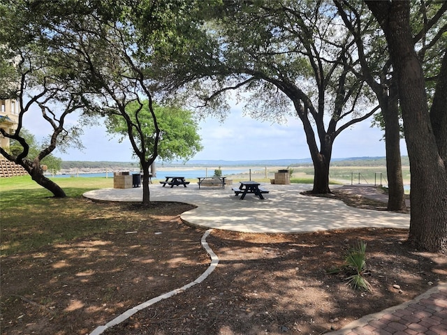 view of property's community with a patio and a water view