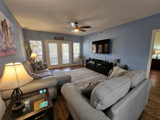 living room with plenty of natural light, dark wood-type flooring, ceiling fan, and french doors