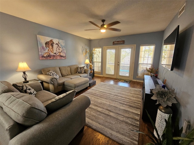 living room featuring french doors, ceiling fan, wood-type flooring, and a textured ceiling