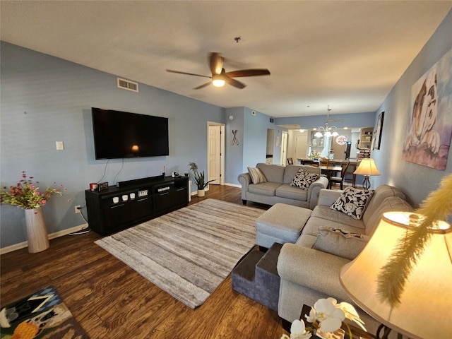 living room with dark wood-type flooring and ceiling fan with notable chandelier