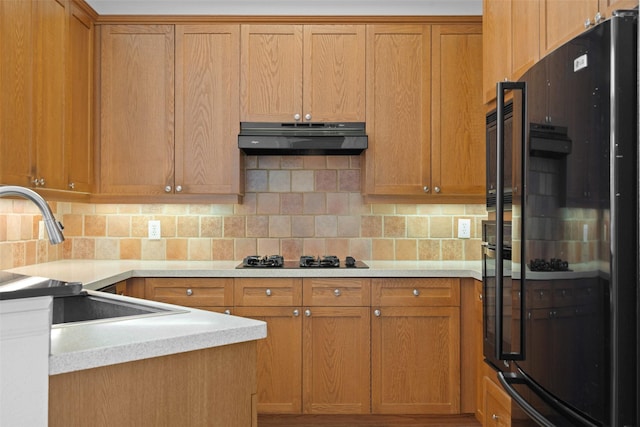 kitchen with black appliances, sink, decorative backsplash, and exhaust hood