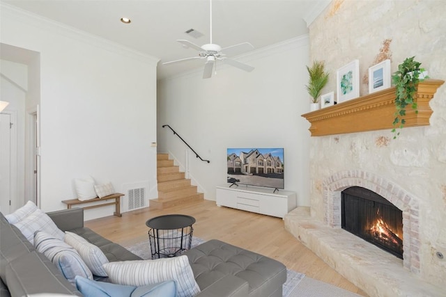 1701 Spyglass Dr Unit 11, Austin, TX 78746 - living room featuring a lit fireplace, wood finished floors, ornamental molding, ceiling fan, and stairs