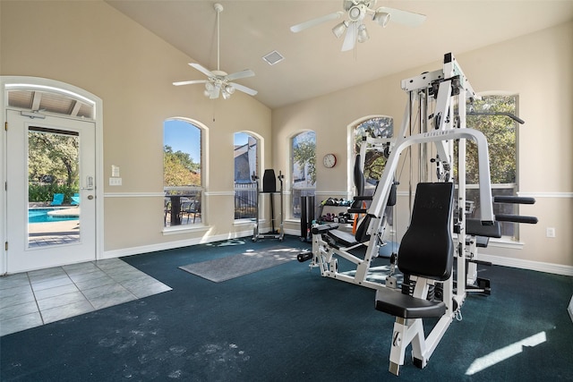 exercise room featuring a towering ceiling, a wealth of natural light, and dark colored carpet