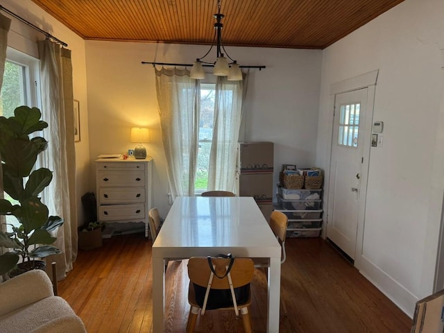 dining area featuring ornamental molding, wood-type flooring, and wooden ceiling