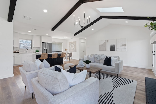 living room with lofted ceiling with skylight, sink, a chandelier, and light wood-type flooring