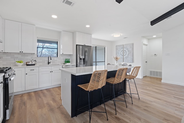 kitchen featuring stainless steel appliances, a center island, and white cabinets