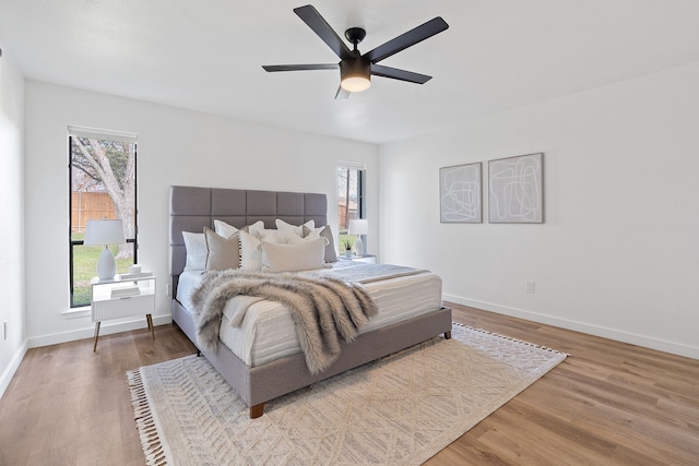 bedroom featuring multiple windows, light wood-type flooring, and ceiling fan