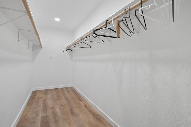 walk in closet with light hardwood / wood-style floors