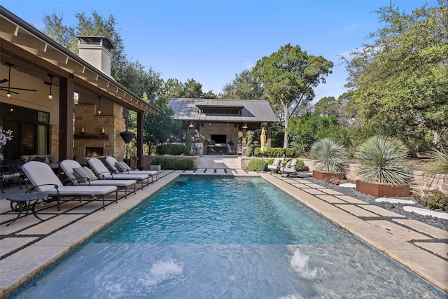 view of swimming pool with a patio and exterior fireplace