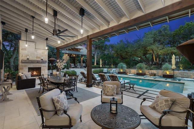 view of swimming pool featuring ceiling fan, a patio, and an outdoor stone fireplace