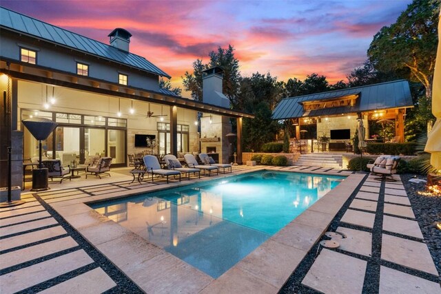 view of pool featuring a patio, an outdoor living space with a fireplace, and ceiling fan