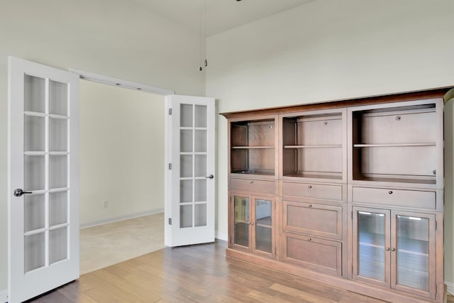 interior space featuring french doors, wood-type flooring, and high vaulted ceiling