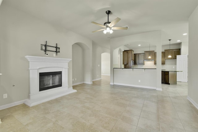 unfurnished living room featuring ceiling fan and light tile patterned floors